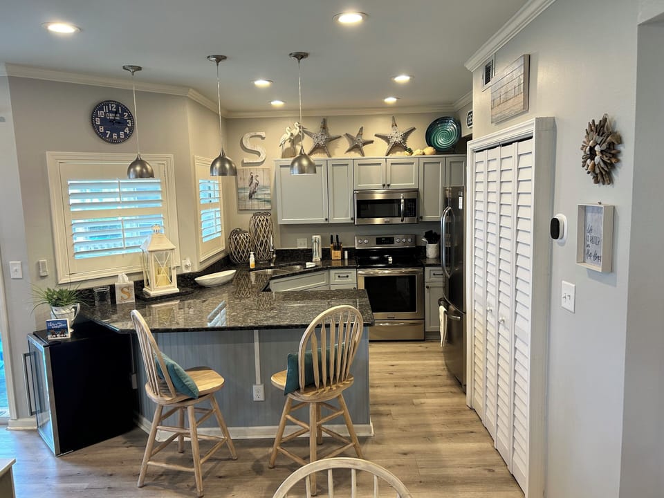 You'll love cooking in this bright coastal kitchen with granite counters, stainless appliances, and charming nautical touches throughout.