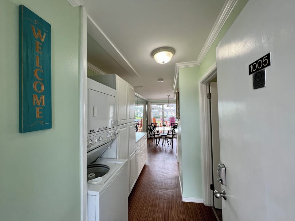 Step into your welcoming space where convenient laundry facilities line the hallway, leading to your bright dining area beyond.