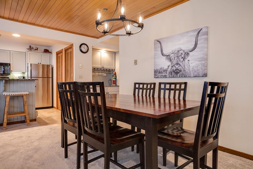 Gather around your spacious dining table for memorable meals with warm wood accents and stylish lighting creating the perfect atmosphere.