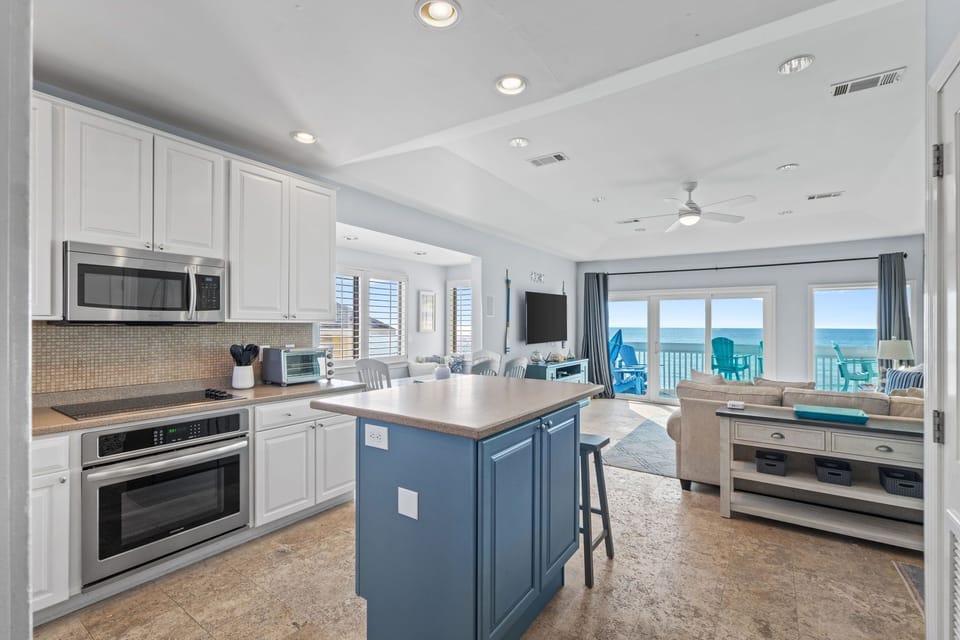 Your gourmet kitchen opens to stunning ocean views, creating the perfect backdrop for cooking and entertaining during your beachfront getaway.