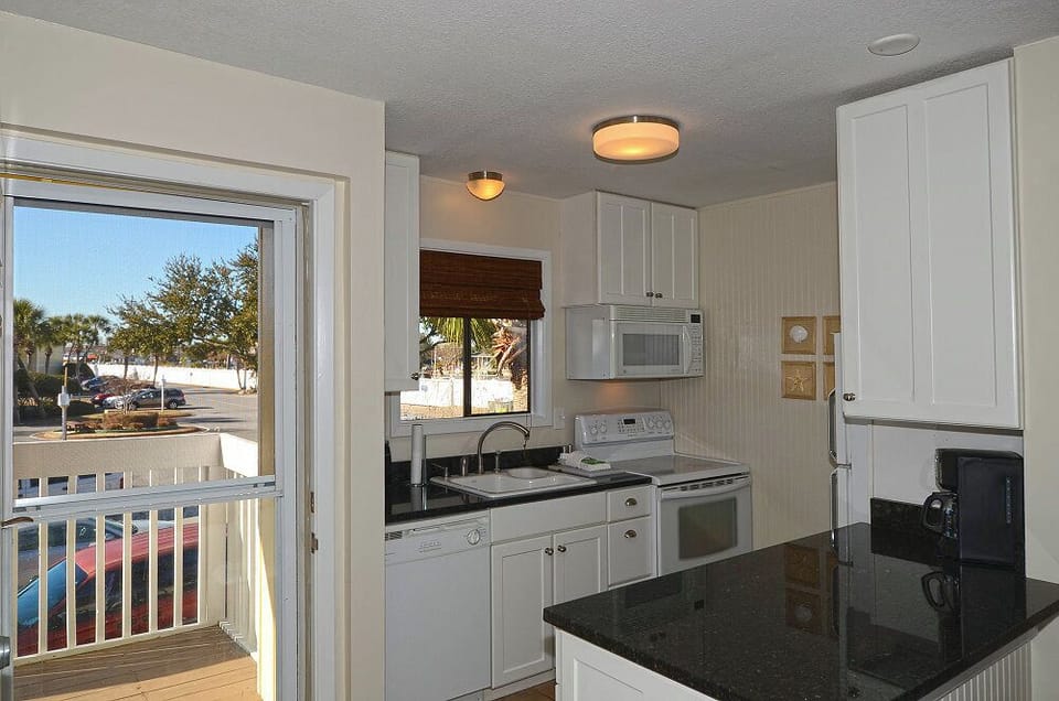 Your bright kitchen opens to a private balcony, featuring modern appliances and granite countertops for easy meal prep during your stay.