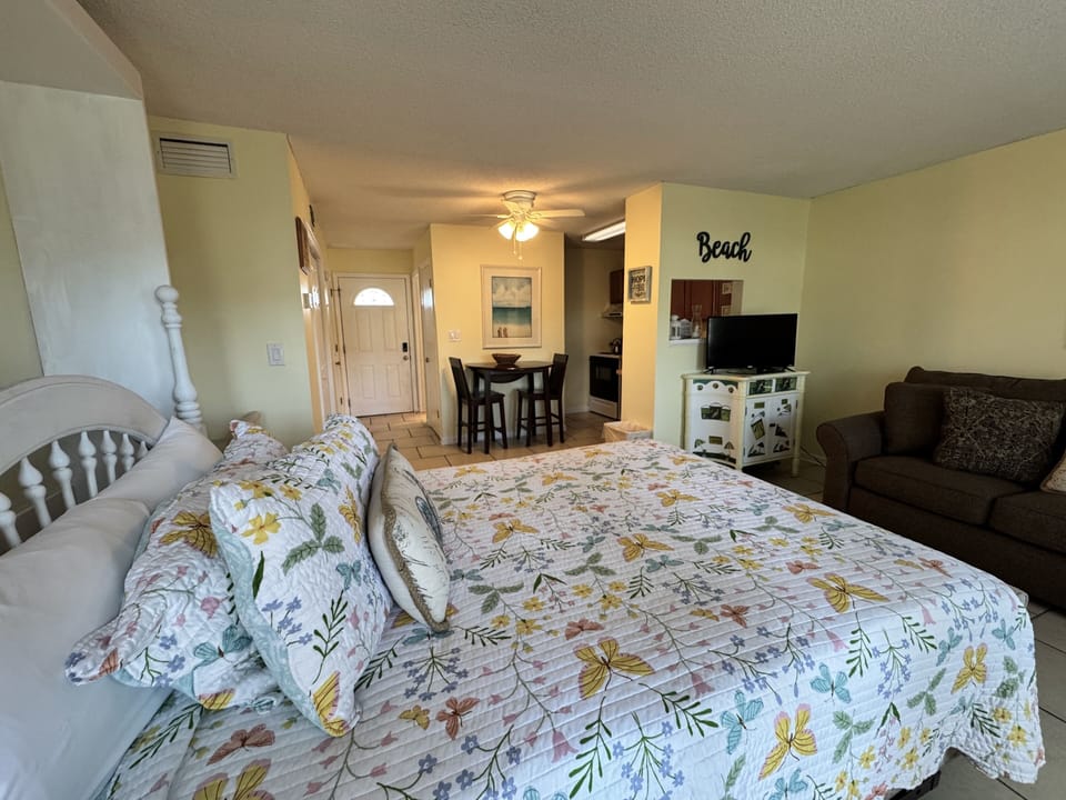 Your cozy beach-themed studio welcomes you with comfortable bedding and an open layout connecting sleeping, dining, and lounging areas perfectly.