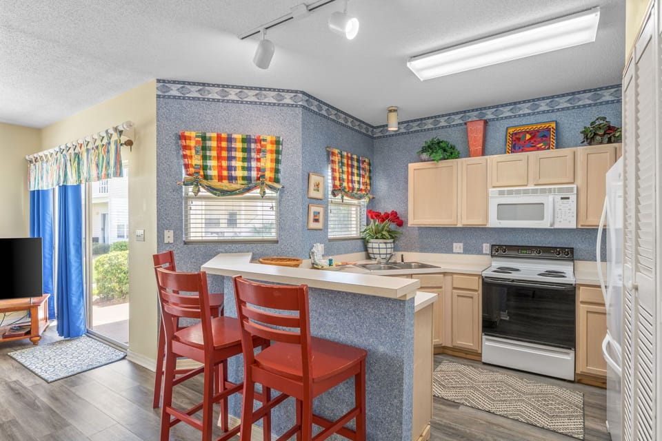 Your cheerful kitchen features vibrant blue walls, full appliances, and a breakfast bar where you can start mornings with coffee and conversation.