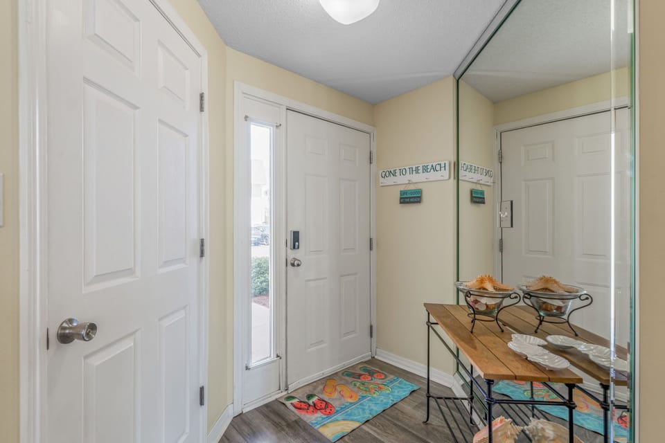 Step into your coastal retreat through this welcoming entrance, complete with beach-themed touches and a convenient bench for settling in.