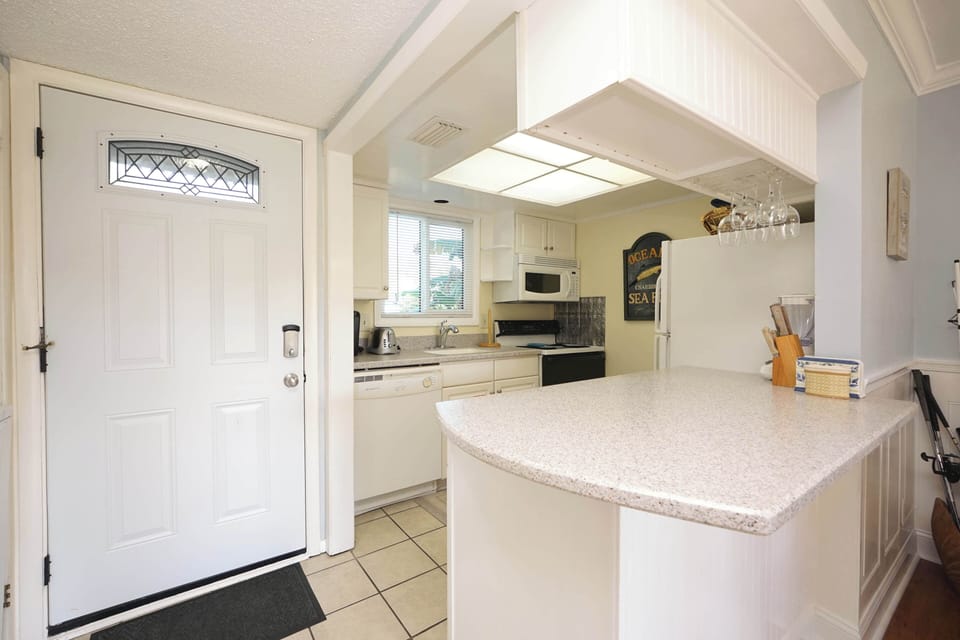 Step into your bright, fully-equipped kitchen where cooking becomes a joy with granite counters, modern appliances, and charming coastal touches.