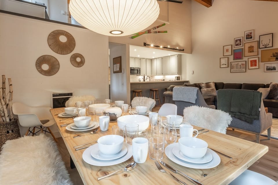 Gather around your beautifully set dining table, where warm wood meets cozy textures and thoughtful details create the perfect atmosphere for memorable meals together.