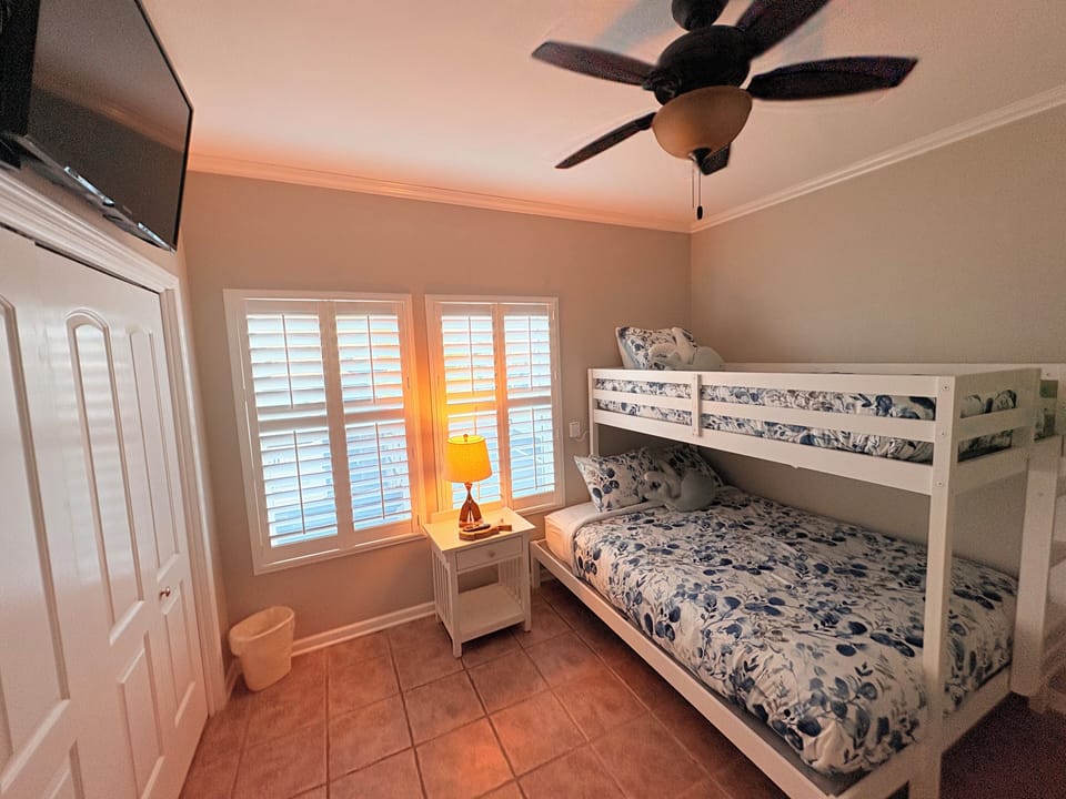 Your kids will love this cozy bunk bed retreat, complete with ceiling fan, TV, and warm ocean views through shuttered windows.