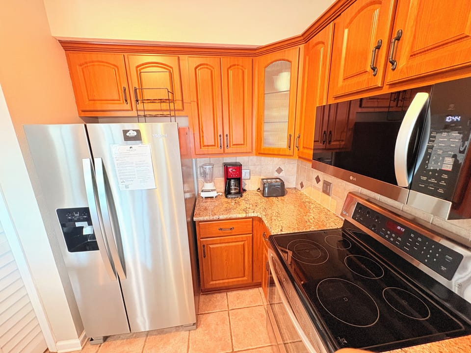 Your fully equipped kitchen features granite counters, stainless appliances, and warm wood cabinets—perfect for preparing meals during your stay.