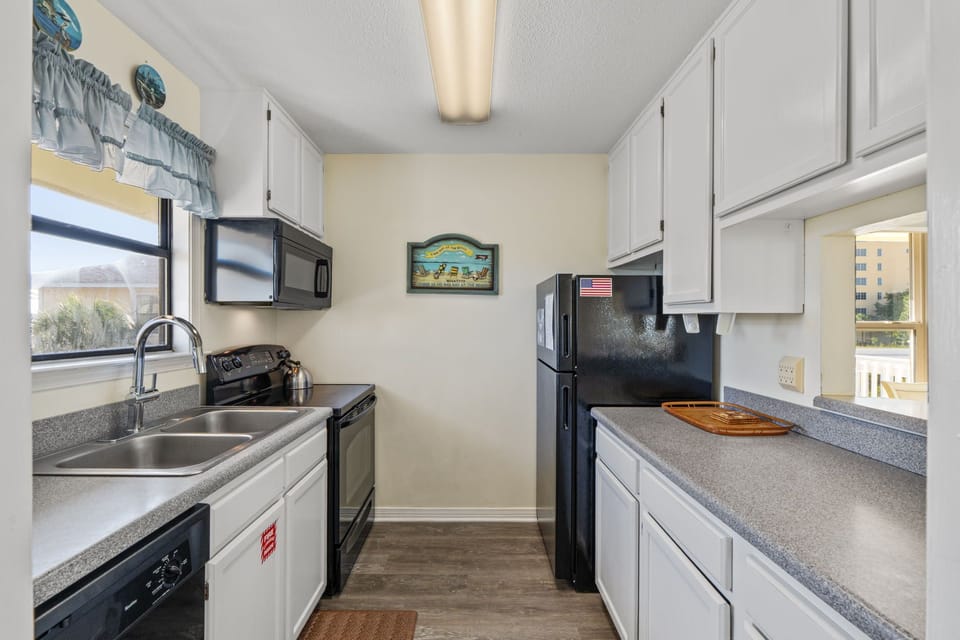 Your fully equipped galley kitchen has everything you need to prepare home-cooked meals, with modern appliances, ample counter space, and bright natural light streaming through the windows.