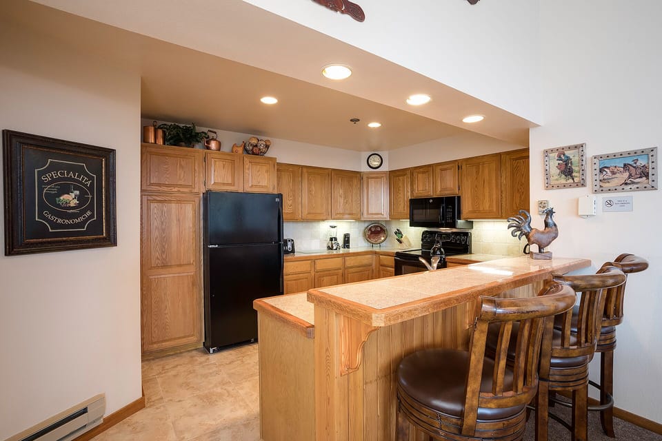 Your fully equipped kitchen features warm oak cabinets, modern appliances, and a breakfast bar where you can enjoy morning coffee together.