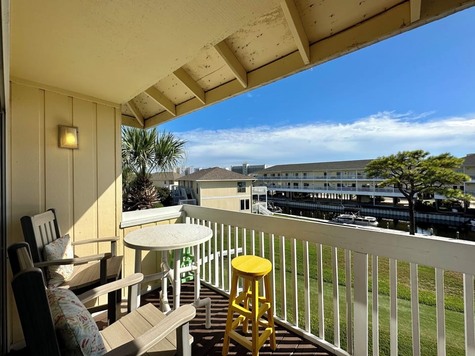 Sip your morning coffee on this charming balcony with colorful seating and peaceful views of the surrounding area.