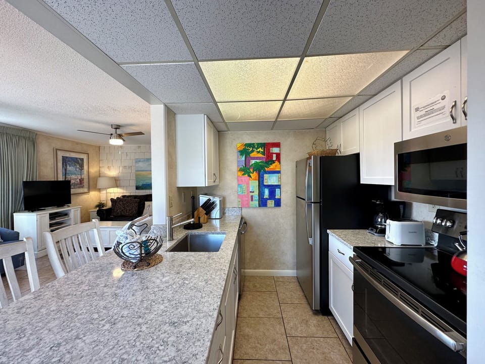 Your fully-equipped kitchen flows into a cozy living space, perfect for preparing meals and gathering together during your stay.