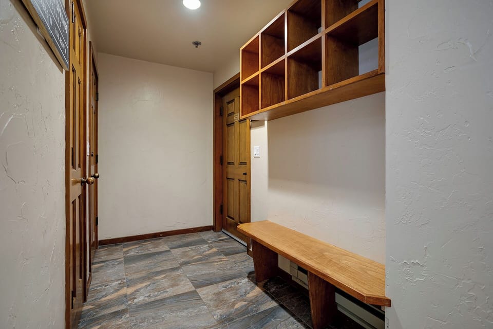 Step into your private mudroom with custom wood storage cubbies and built-in bench—perfect for organizing gear after mountain adventures.