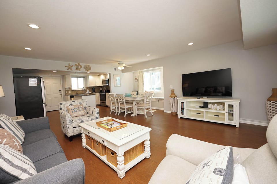 Step into your coastal retreat with an open living space featuring comfortable seating and ocean-themed touches throughout.