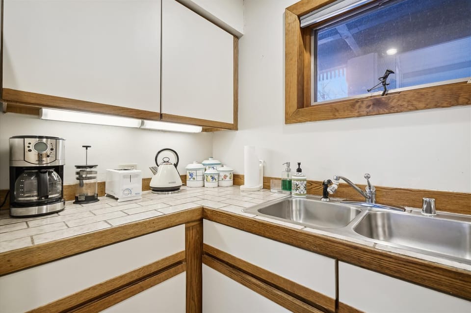 This kitchen has a gas stove, microwave, Toaster oven, and coffee pot.