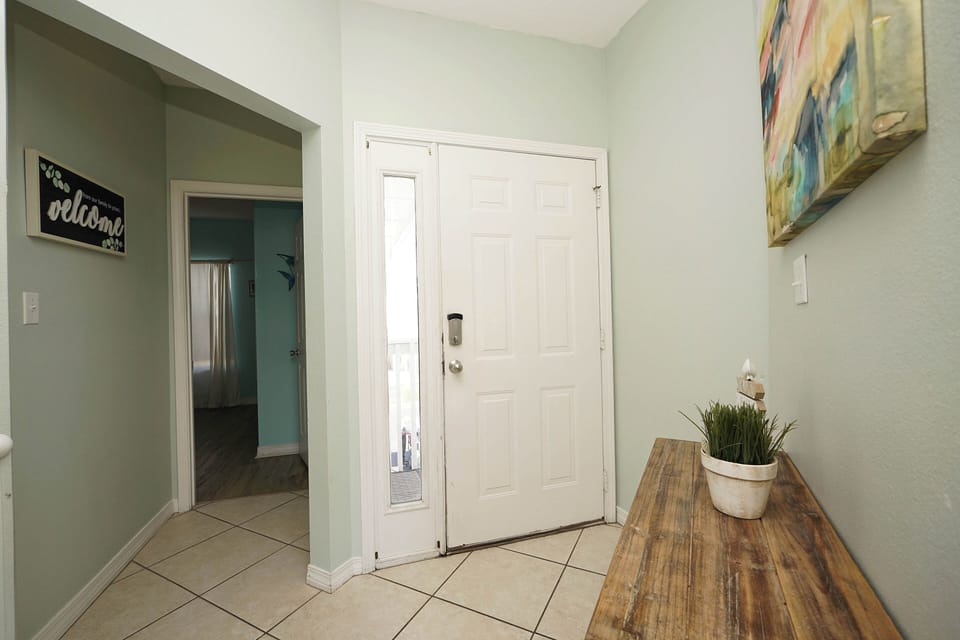 Step into your welcoming entryway where warm artwork and fresh greenery create an inviting first impression of your home away from home.