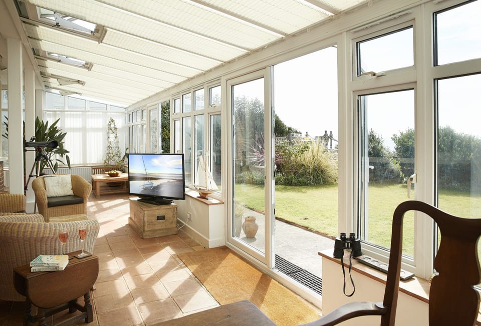 Ground floor: The spacious conservatory with dining table and further seating