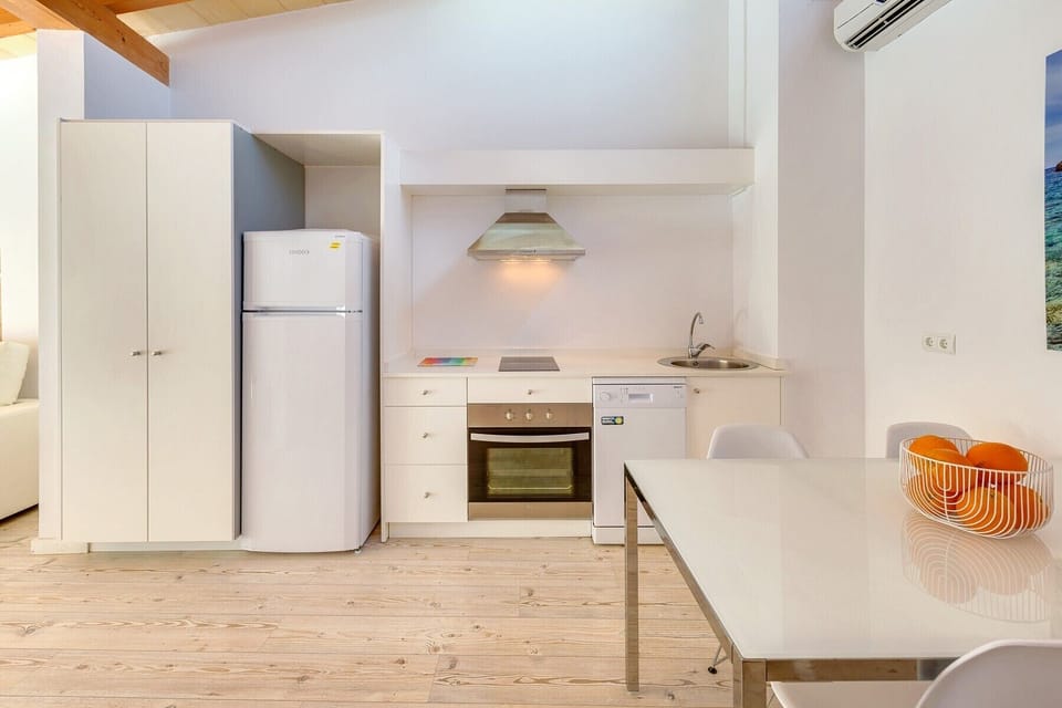 The kitchen of the URBAN SUITES Palma 4 holiday apartment is equipped with an oven, electric cooktops, coffee maker, kettle, toaster, dishwasher, fridge and freezer.