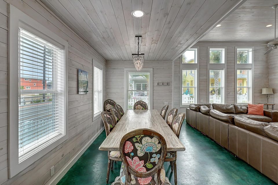 Gather around your elegant dining table beneath a sparkling chandelier, where memorable meals unfold in this bright, airy space.
