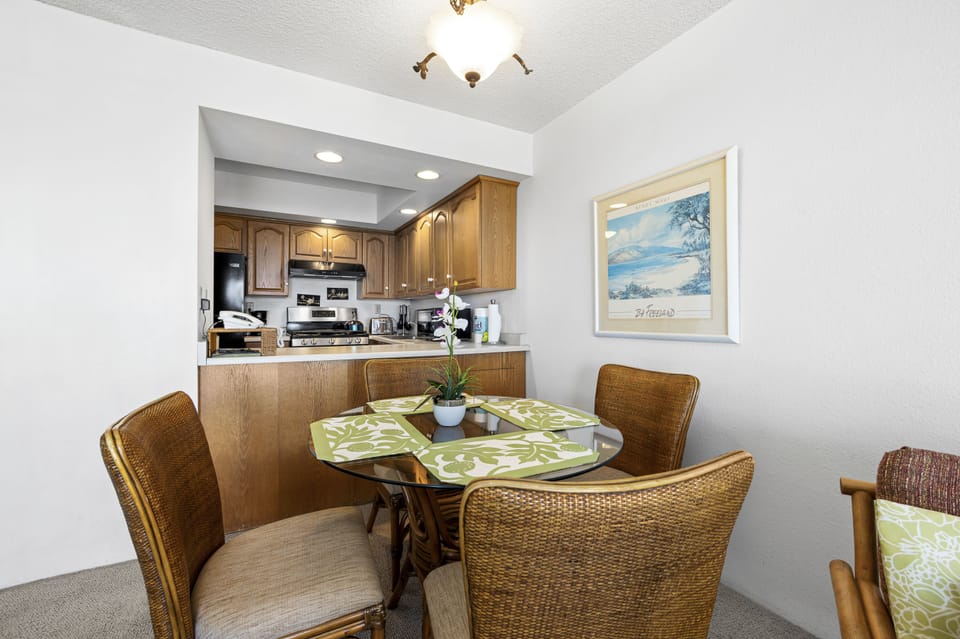 Gather around your dining table for meals or morning coffee, with a fully equipped kitchen just steps away. The coastal artwork and warm wood tones create a welcoming space for your vacation memories.