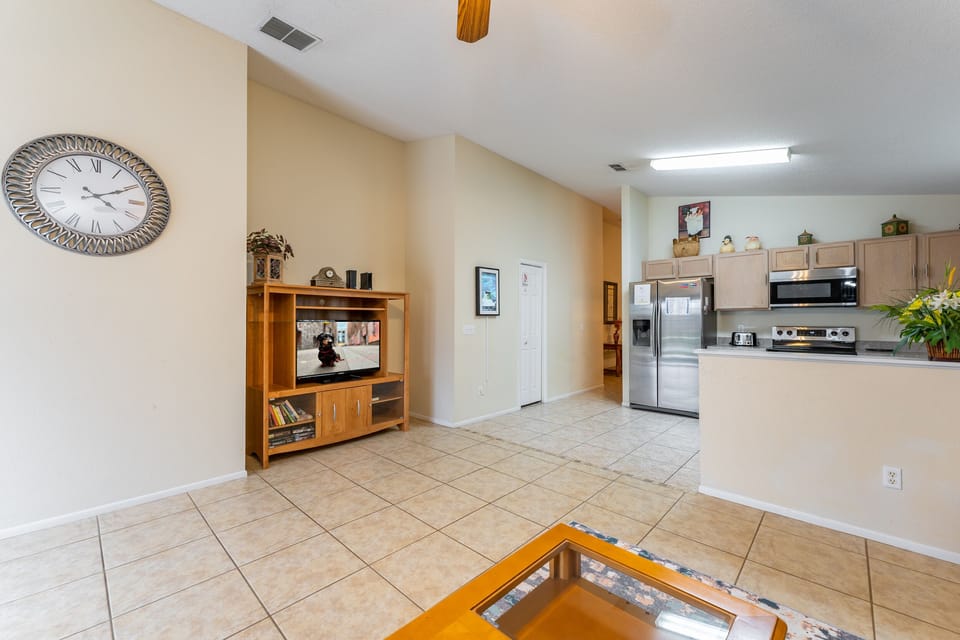 Open plan living area with comfortable seating, TV, and easy flow into the fully equipped kitchen, ideal for relaxing together after a day out.