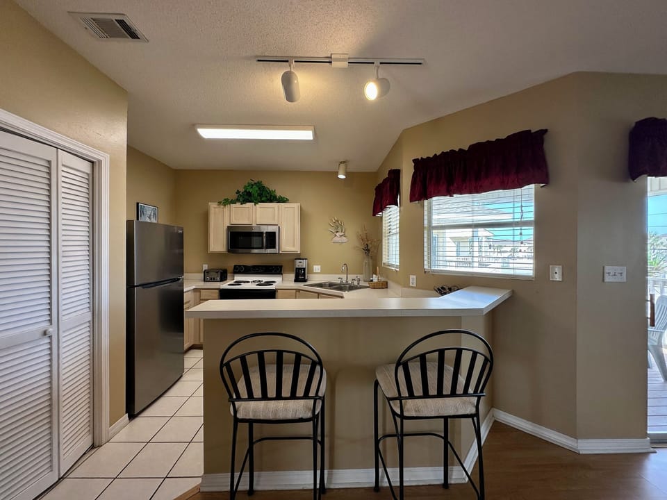 Your fully equipped kitchen features modern appliances and a breakfast bar where you can start your mornings with coffee.