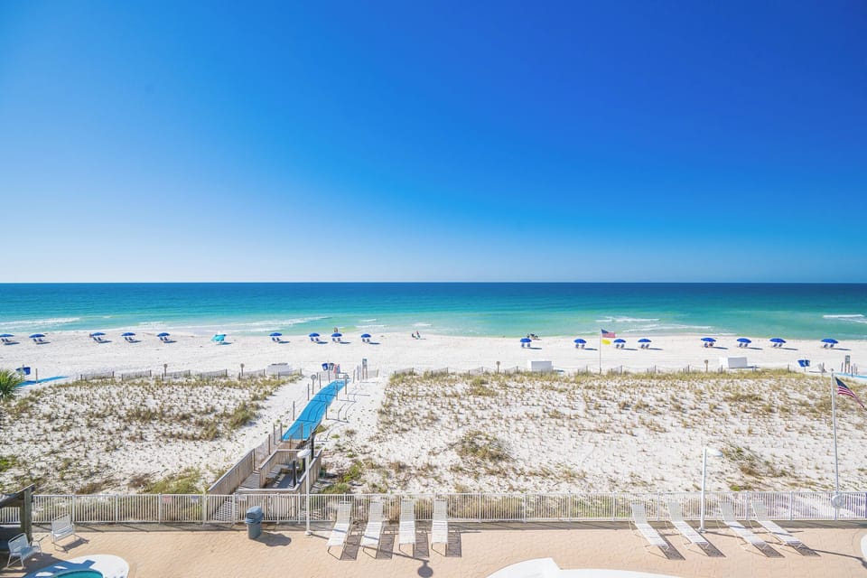 Your eyes follow the clear blue horizon while cool coastal sounds drift from the beach below