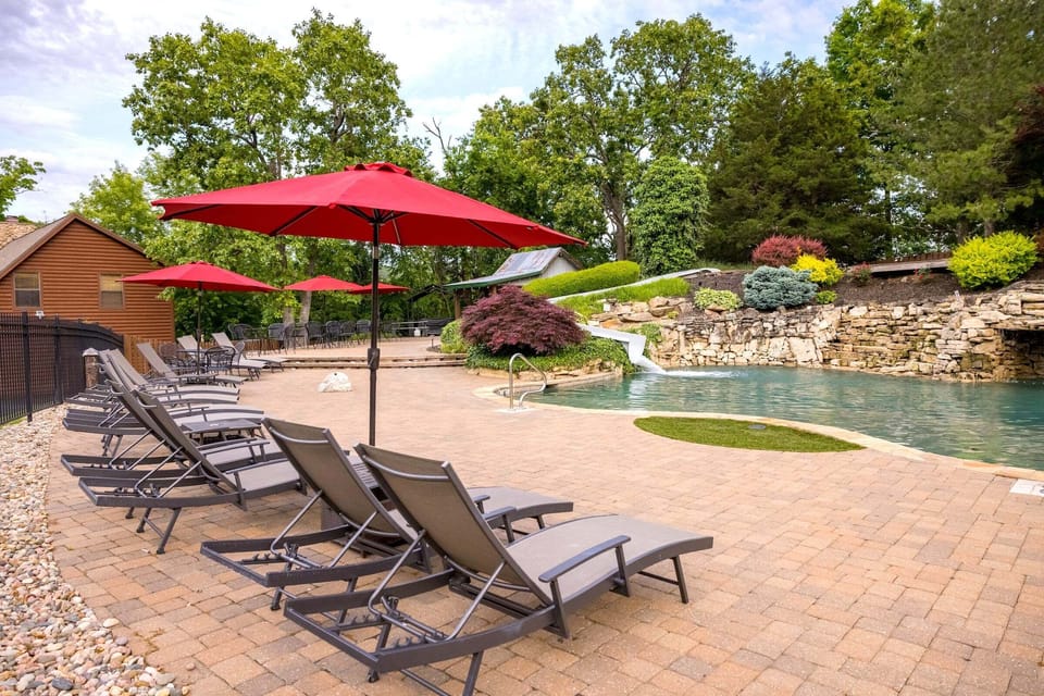 Main pool on the resort with plenty of loungers, waterslide, and waterfalls throughout