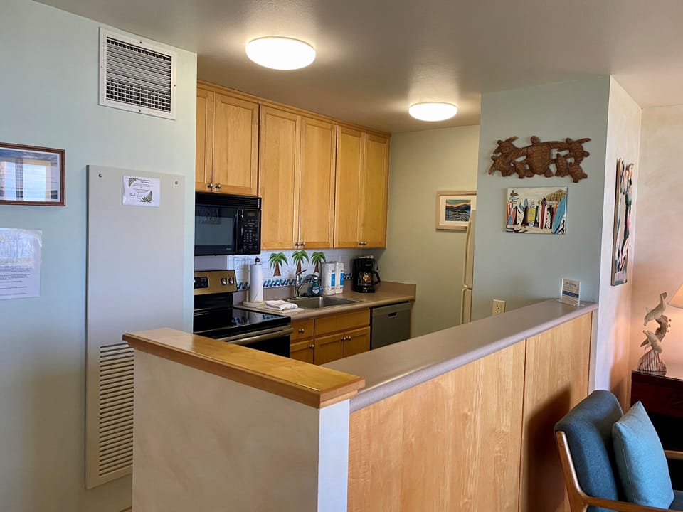 Your fully equipped kitchen features warm wood cabinetry, modern appliances, and a convenient breakfast bar—perfect for preparing home-cooked meals during your stay.