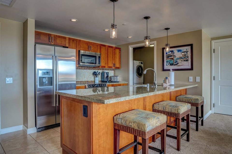 Chic granite island kitchen with bar seating and modern appliances.