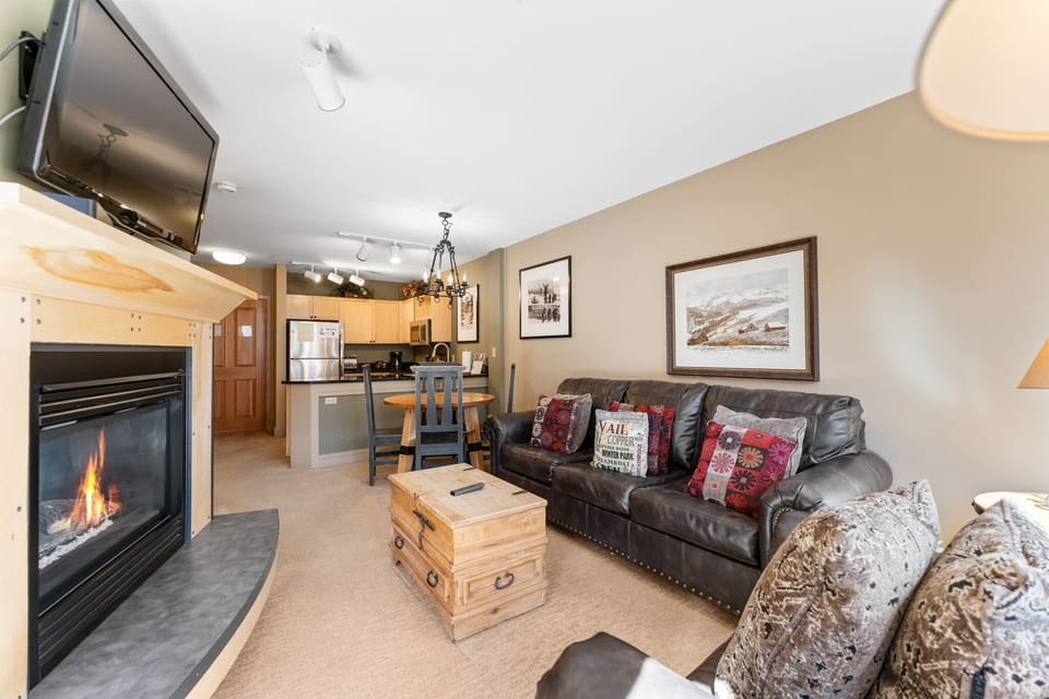 Cozy up by the crackling fireplace in this welcoming living space with full kitchen, perfect for your mountain getaway.