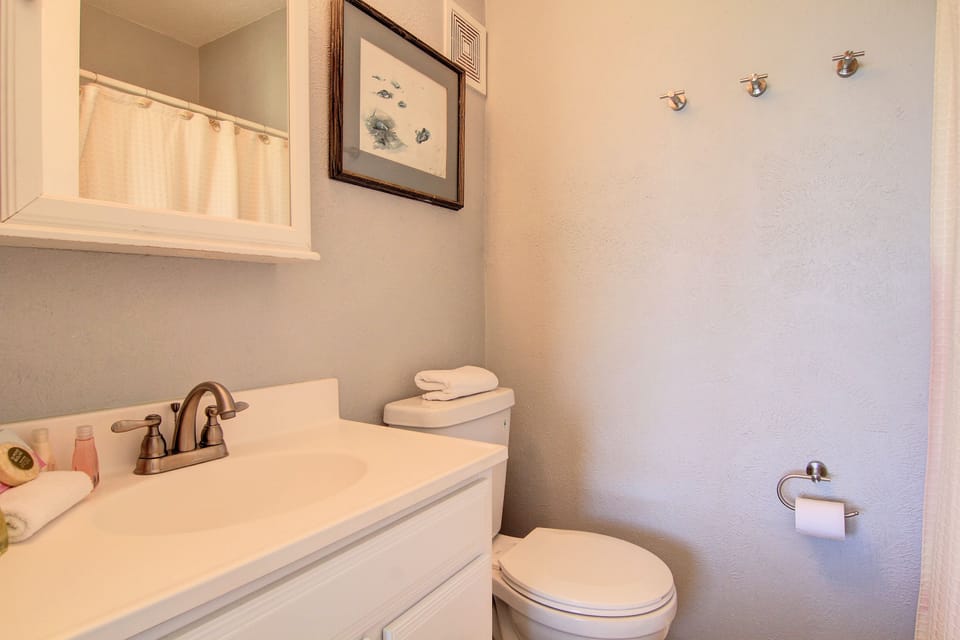 Step into your private bathroom featuring clean lines, thoughtful coastal artwork, and fresh towels ready for your arrival.