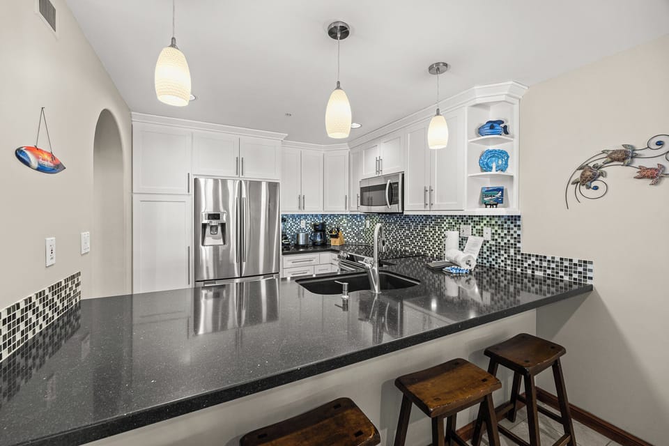 Step into your fully equipped gourmet kitchen with granite counters, stainless appliances, and breakfast bar seating for casual meals.