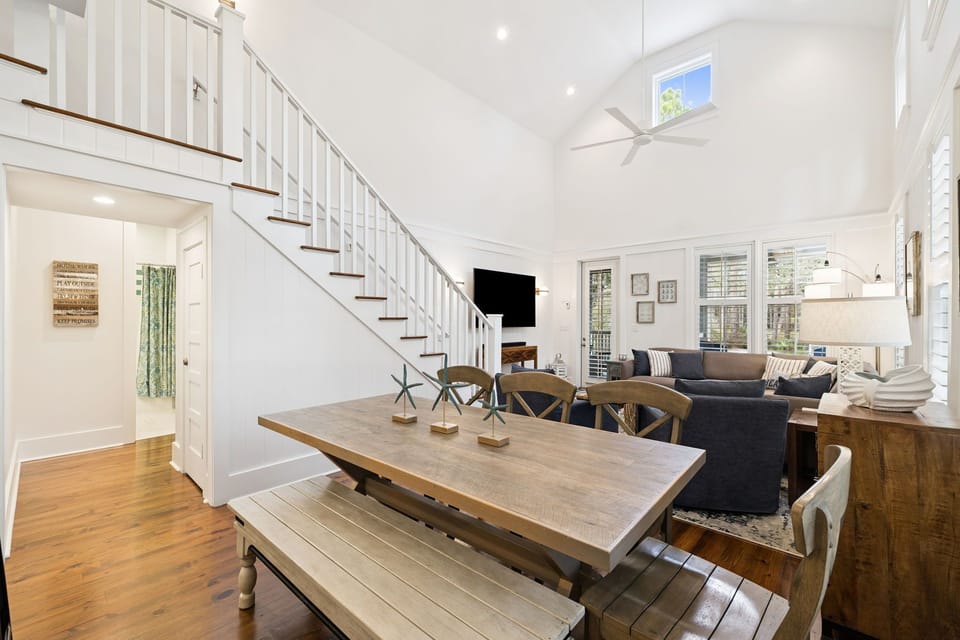 Unwind in your spacious living area where rustic dining meets modern comfort, with soaring ceilings and natural light streaming through large windows.