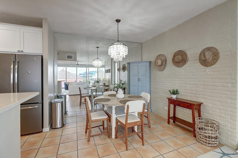 Gather around this inviting dining space where sparkling chandeliers illuminate your meals and coastal charm surrounds you with natural textures and ocean-inspired decor.