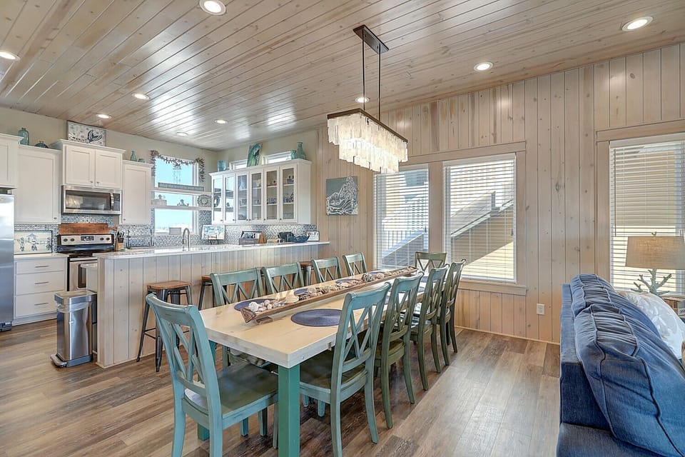 Your open-concept living space combines kitchen, dining, and lounge areas with coastal charm—perfect for gathering with loved ones after beach days.