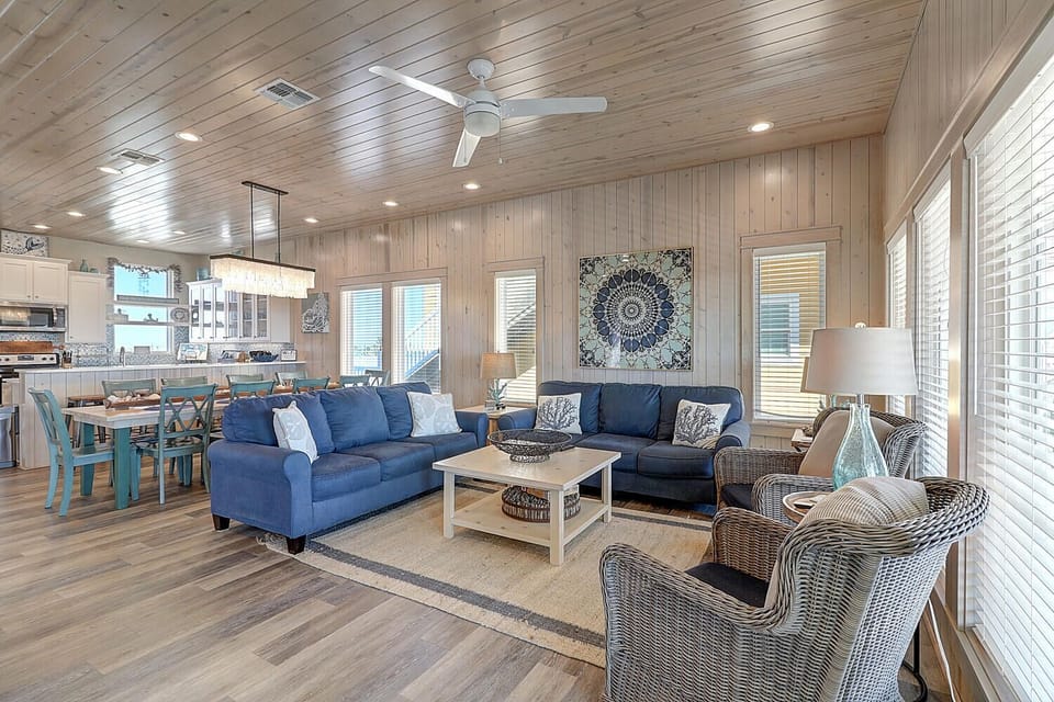 Relax in this bright, coastal living space with plush blue sofas and stylish furnishings—your perfect retreat for memorable vacation moments.