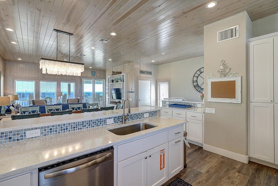 Your spacious kitchen features coastal tile accents, granite counters, and stainless appliances, perfect for preparing meals while enjoying ocean views.
