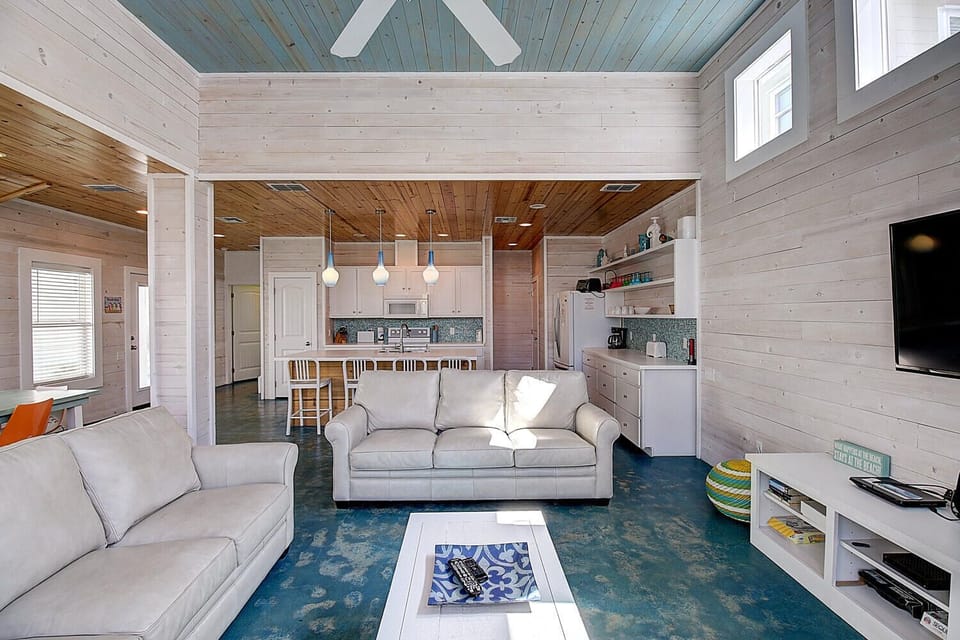 Relax in your open-concept retreat where coastal charm meets modern comfort, featuring soaring ceilings and seamless kitchen-living flow.