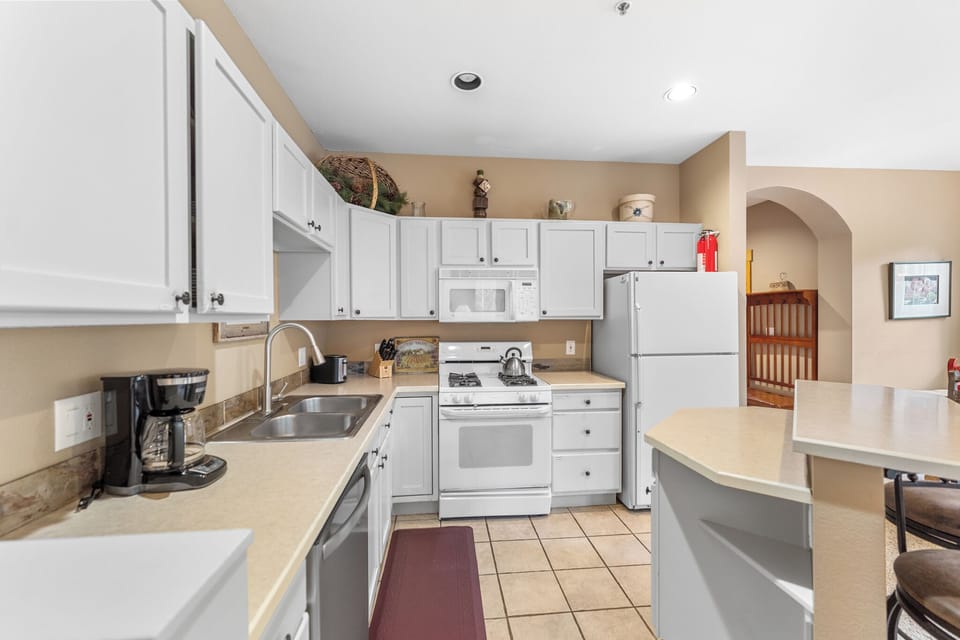Your fully equipped kitchen awaits with white appliances, granite counters, and everything needed to whip up delicious meals during your stay.