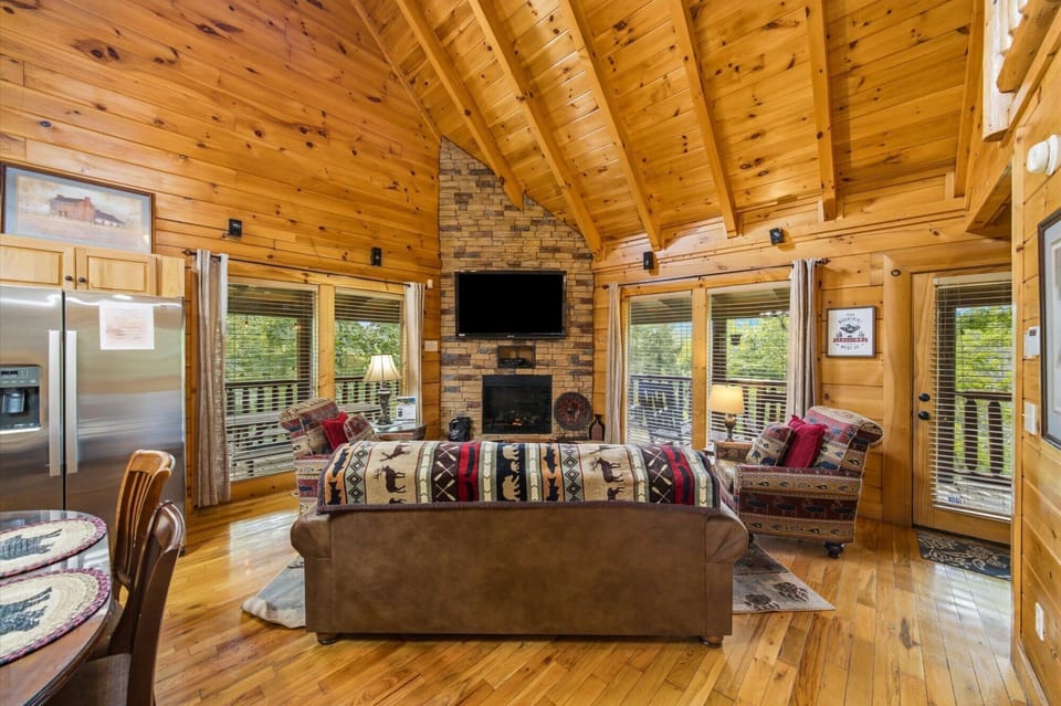 Sink into plush seating beneath soaring wood-beamed ceilings, where warm knotty pine surrounds you and natural light pours through expansive windows. Cozy up by the stone fireplace after a day of adventure.