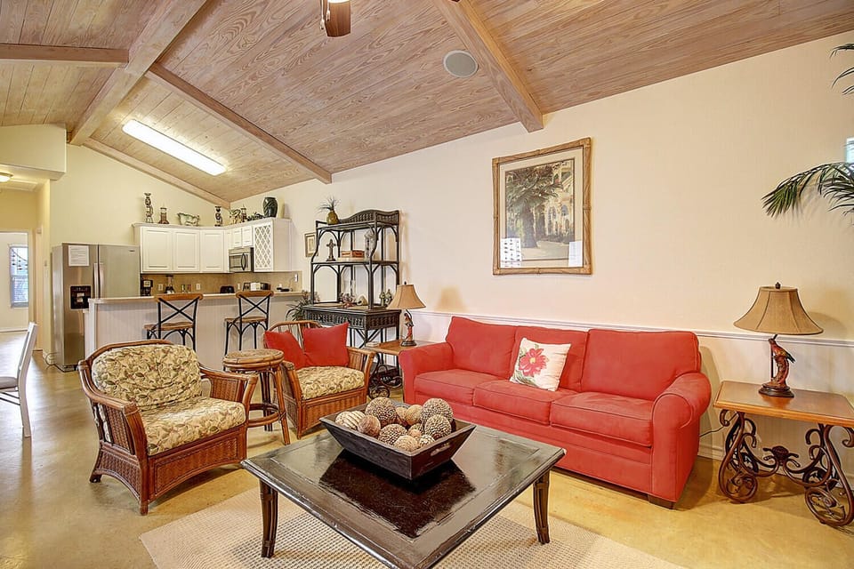 Your open-concept living room flows seamlessly into a fully equipped kitchen, creating the perfect space to relax on the coral sofa or gather around the coffee table.