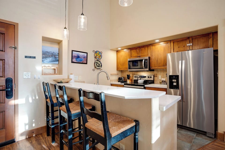 Your spacious kitchen awaits with stainless steel appliances, granite countertops, and a breakfast bar perfect for morning coffee.