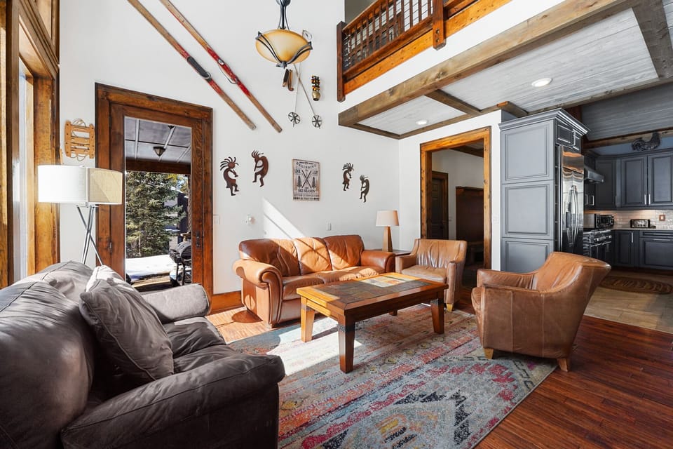 Living area featuring tons of seating for the whole group, vaulted ceilings, gas fireplace, mounted flatscreen TV and access to the private patio.