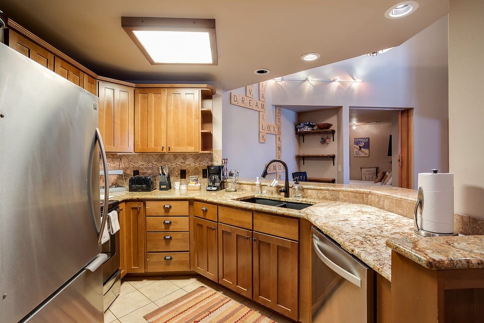 Your fully equipped kitchen features warm wood cabinetry, granite countertops, and stainless steel appliances, creating the perfect space for memorable meals.