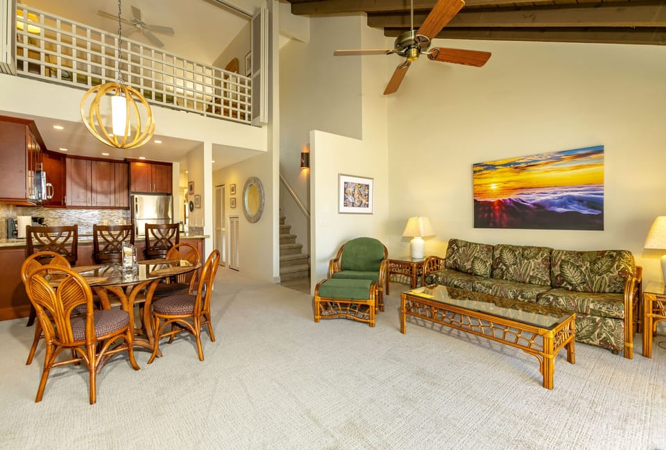 Relax in your spacious open-concept living space with soaring ceilings, tropical-inspired furnishings, and vibrant artwork. Natural light flows through the loft, complementing the polished kitchen and cozy dining area—your perfect home away from home.