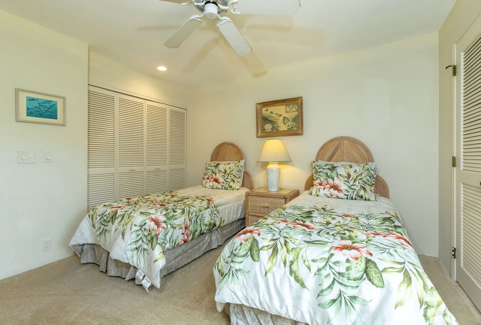 Your tropical twin bedroom awaits with breezy ceiling fan, charming wicker accents, and lush botanical linens that bring the island indoors.