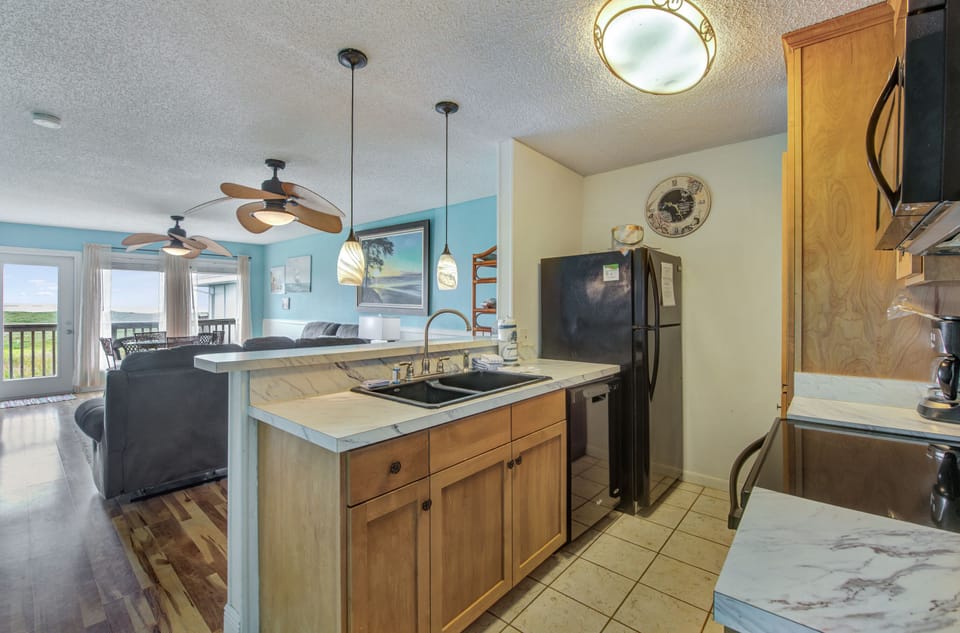 Your fully equipped kitchen flows seamlessly into the living area, perfect for preparing meals while staying connected to your group.