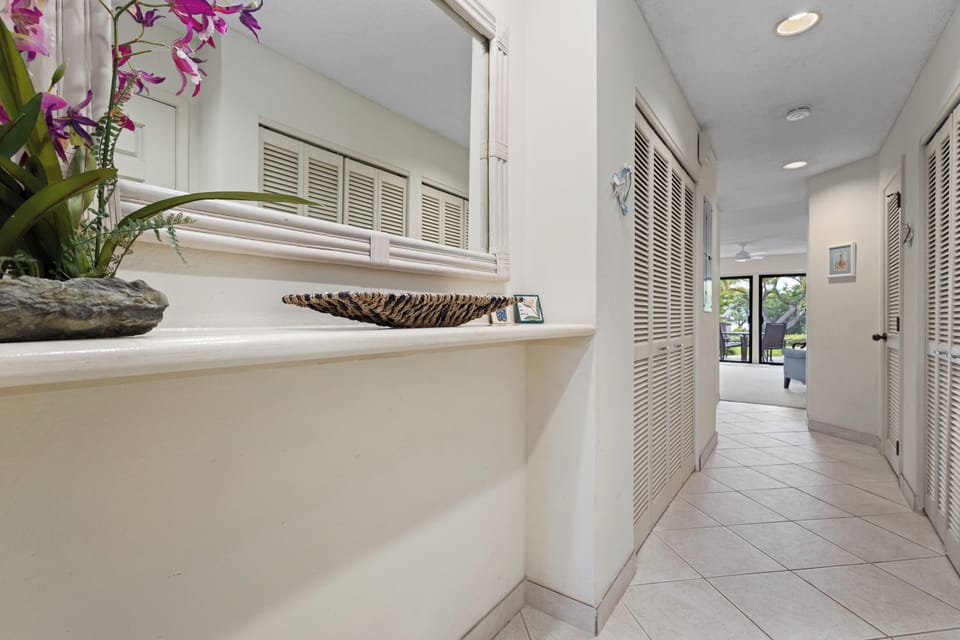 Step into a bright, airy hallway that flows seamlessly through your home. The elegant louvered closets and cheerful floral accents create a welcoming retreat where relaxation begins the moment you arrive.