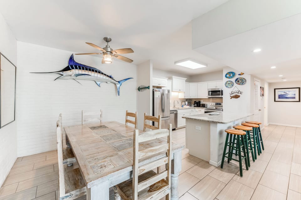 Gather around your coastal-themed dining space featuring rustic charm and modern kitchen with granite counters and stainless appliances.